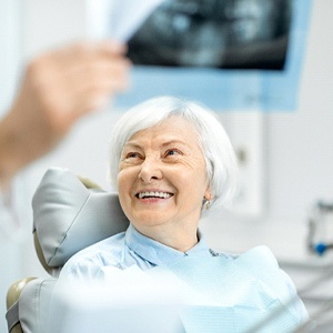 Patient with dentures in Fort Myers smiling at X-ray