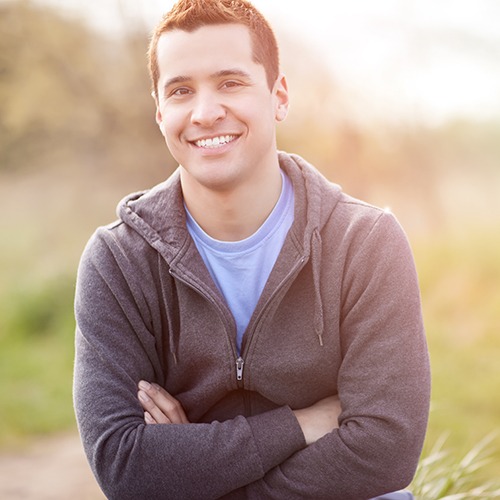 Man in jacket smiling with arms folded