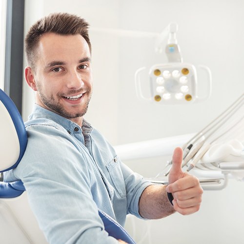 Bearded man in dental chair giving thumbs up