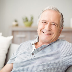 Senior man sitting on a couch and smiling